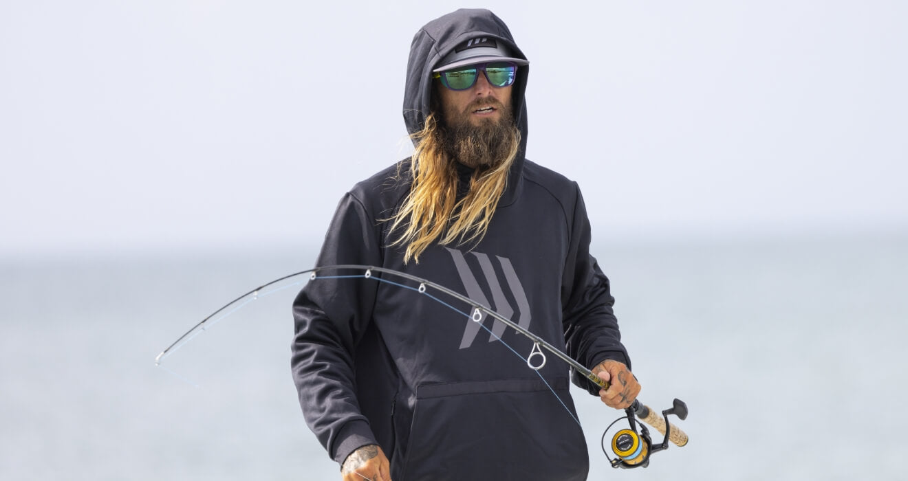 man fishing in a full fishing gear jacket, hat and sunglasses