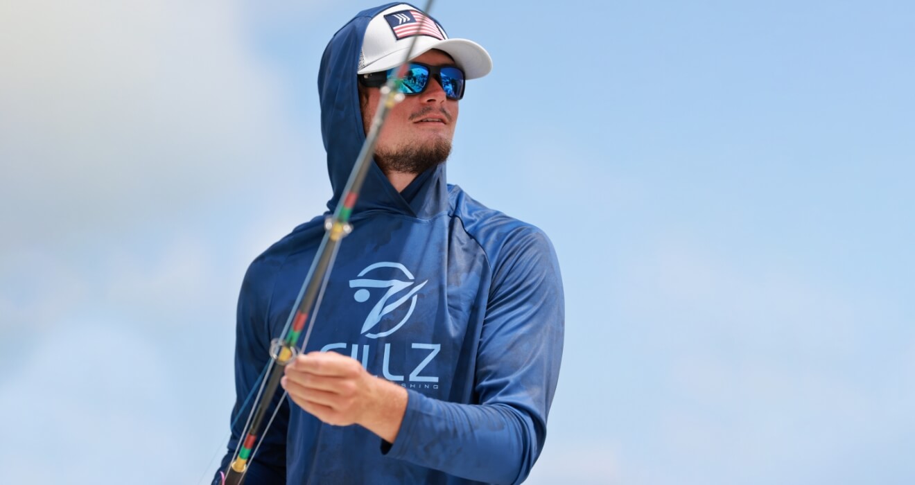 man in dark blue uv hoodie and sunglasses fishing